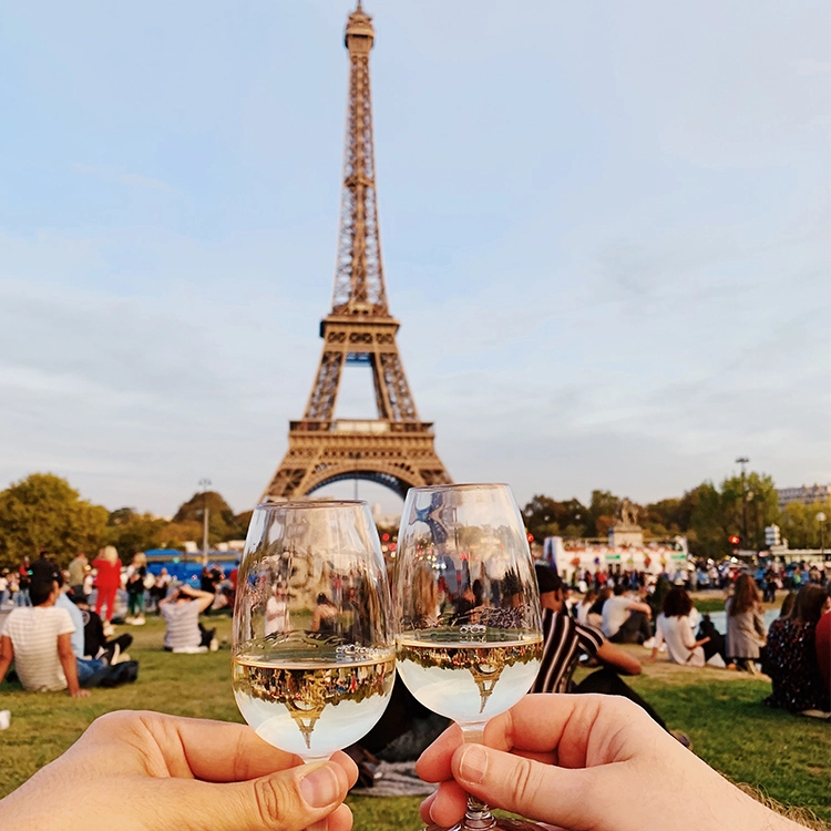 Clinking wine glasses at the Eiffel Tower