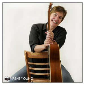 Lisa Koch sitting in a chair holding her guitar